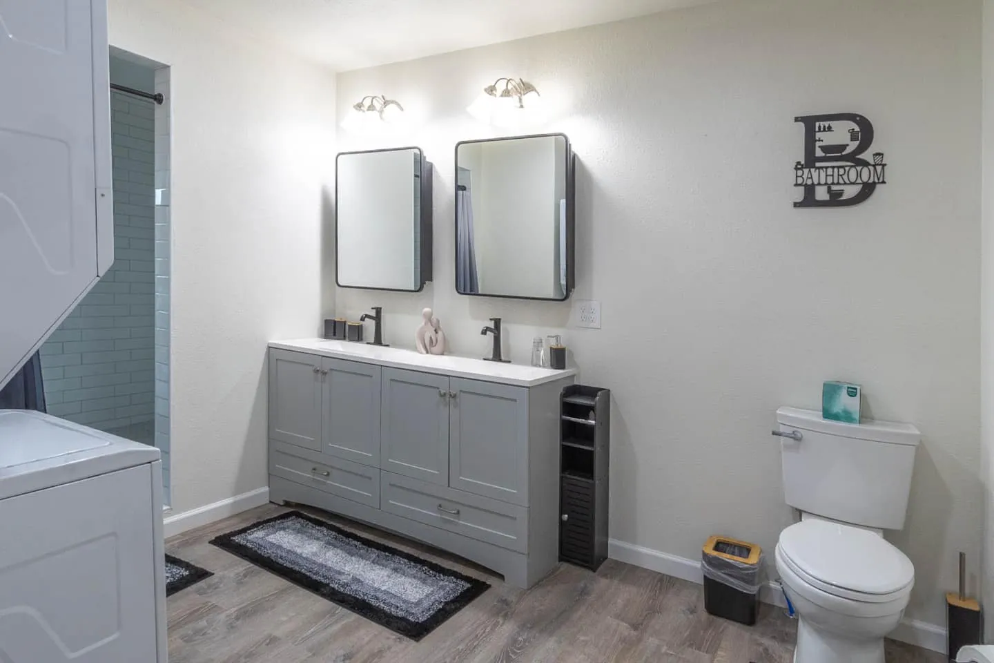 Unit 5 bathroom with a gray vanity and two mirrors