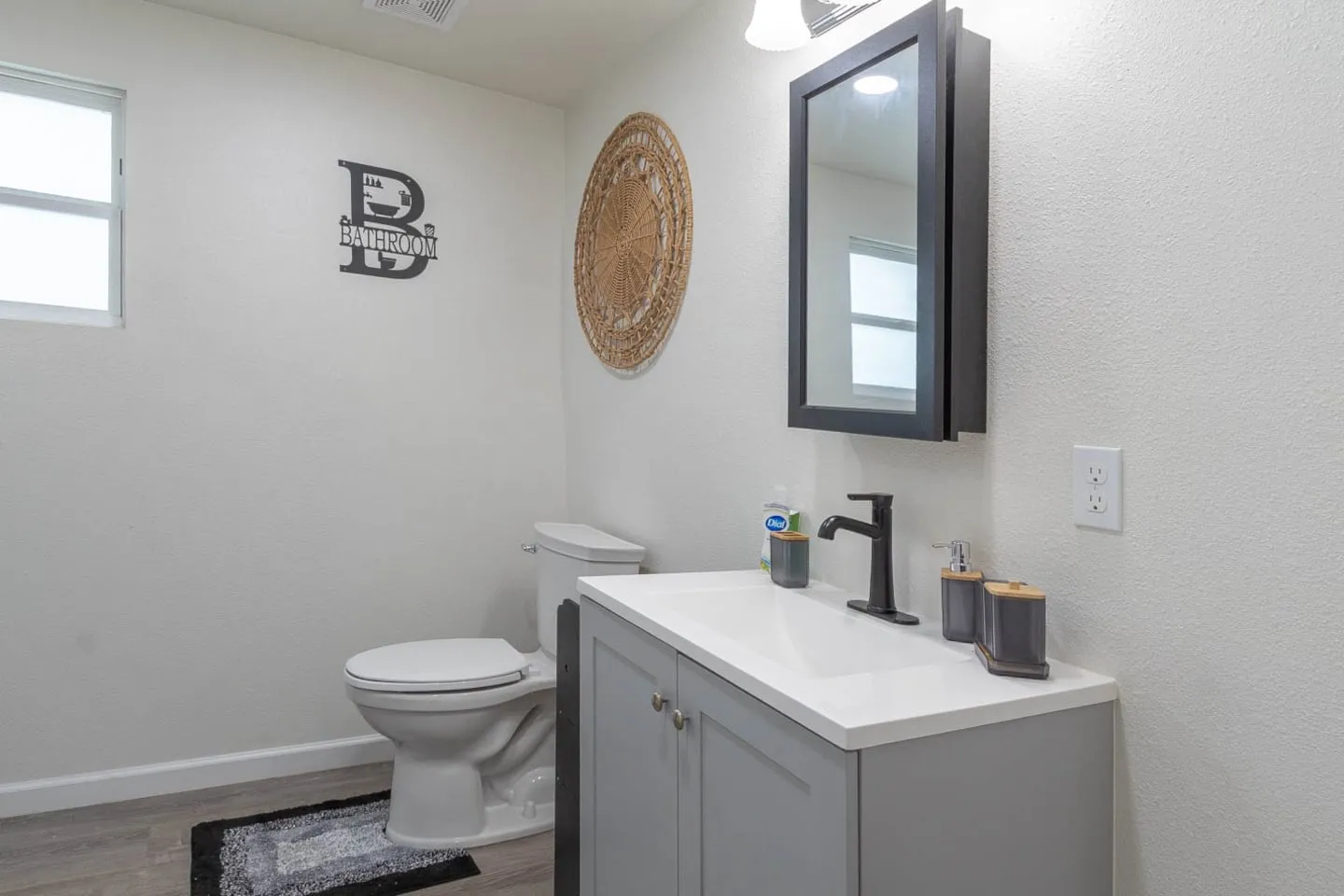 Unit 5 second bathroom with a gray vanity and mirror