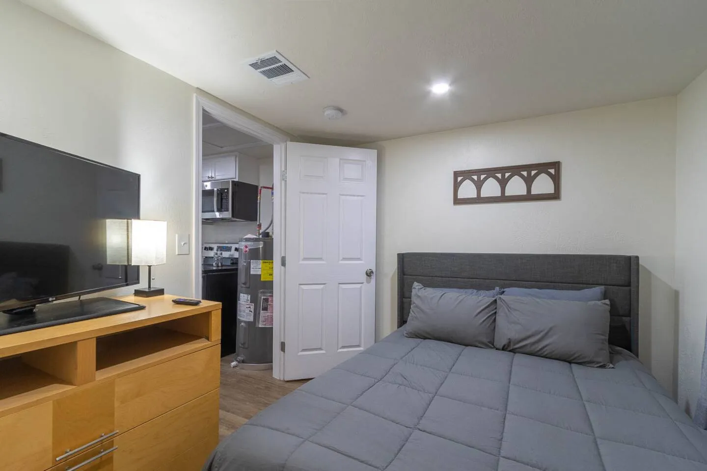 Unit 3 bedroom with a TV on a dresser facing the bed