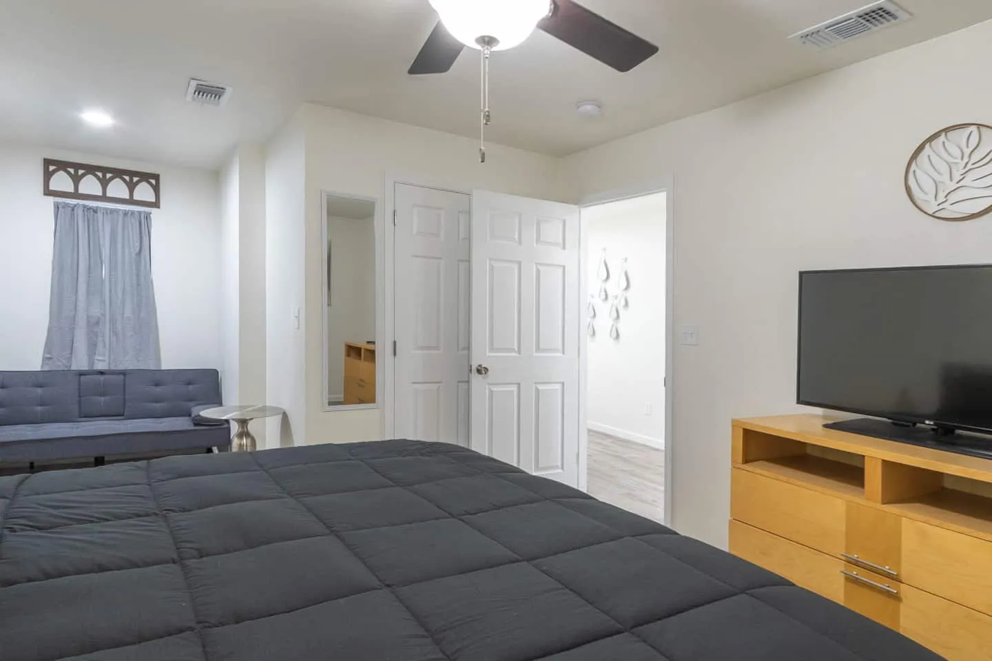 Unit 5 bedroom with a TV on a dresser and a ceiling fan