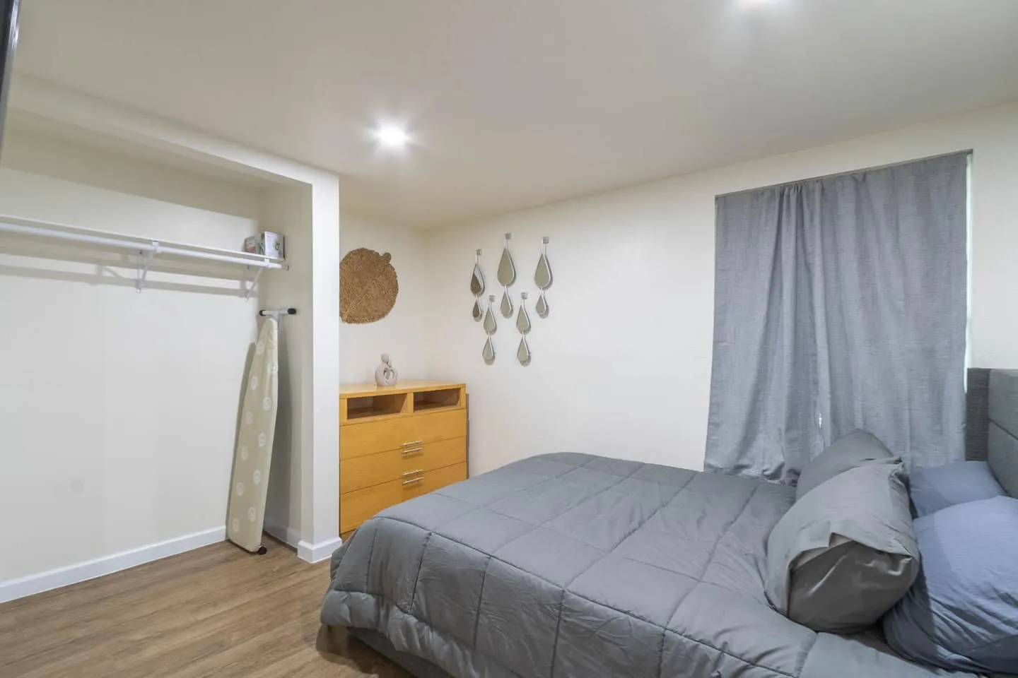 Unit 2 bedroom with gray bedding, an open closet and a dresser