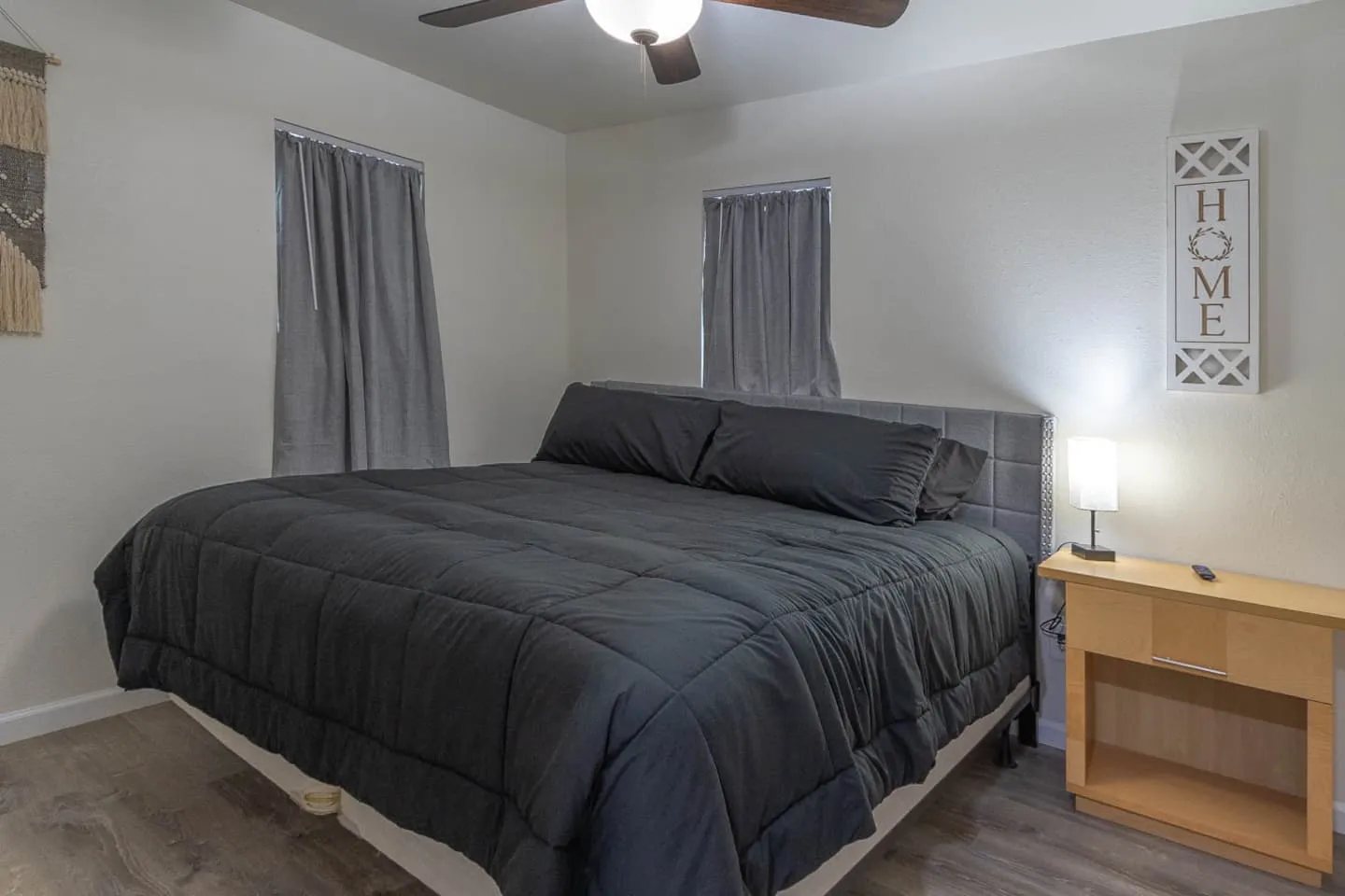 Unit 5 second bedroom with a king bed, nightstand and lamp