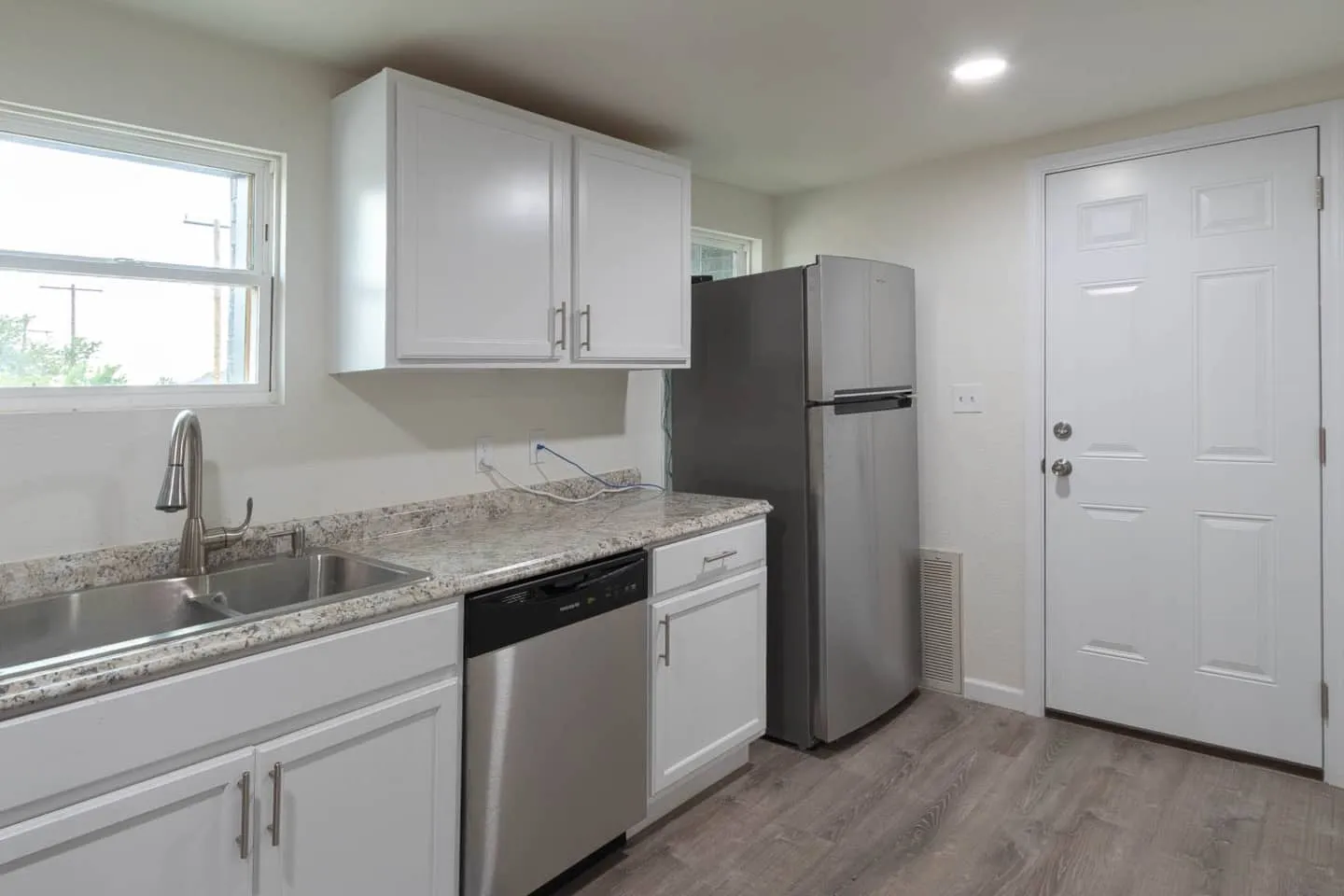 Unit 5 kitchen with a dishwasher, sink and stainless steel refrigerator