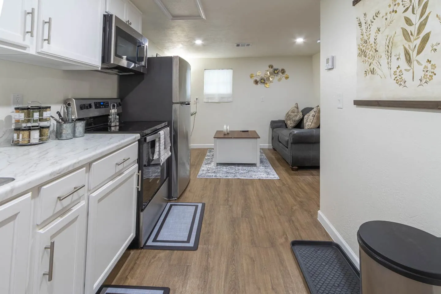 Unit 2 kitchen counter with a stove and microwave, open to the living room