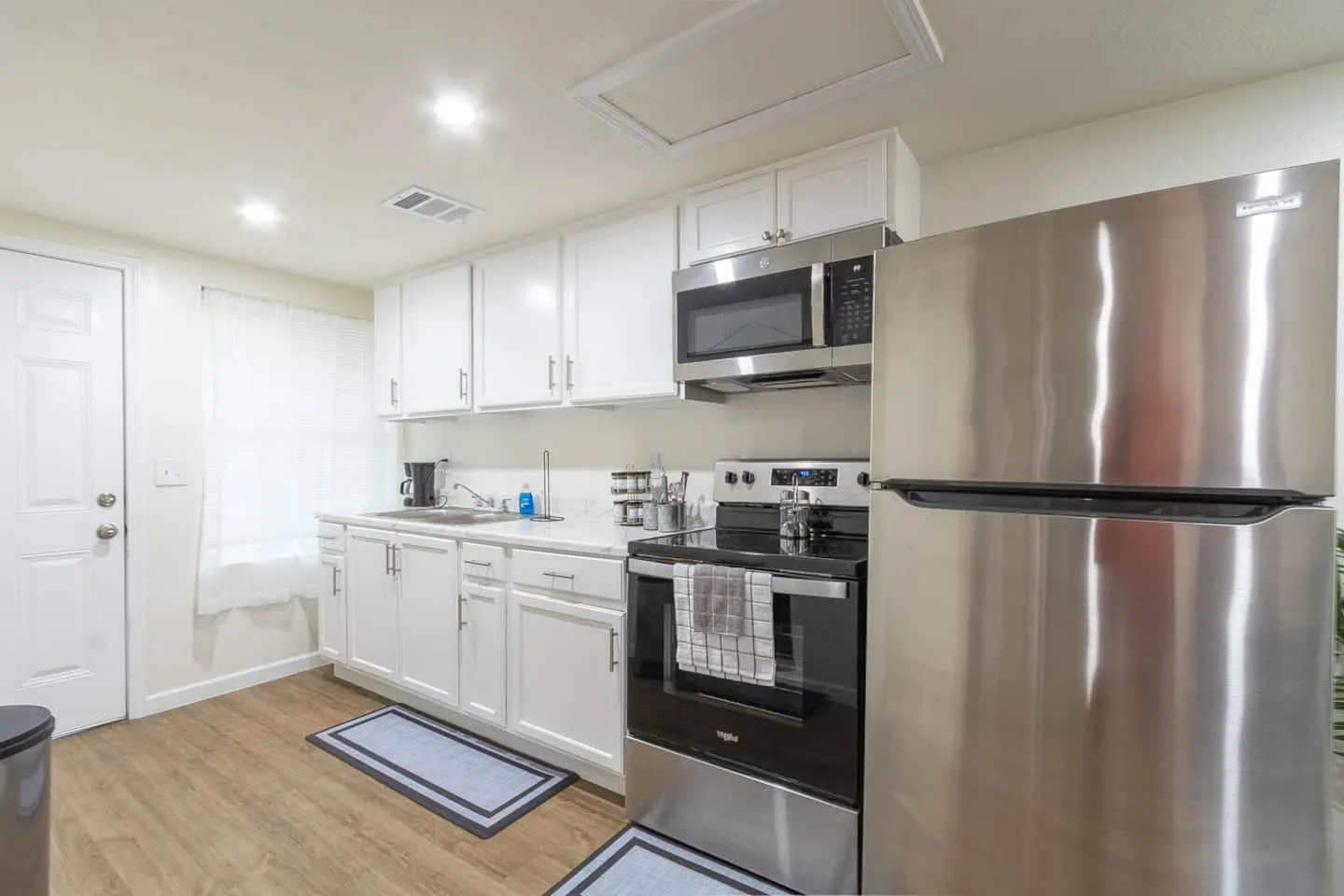 Unit 2 kitchen with white cabinets and stainless steel appliances