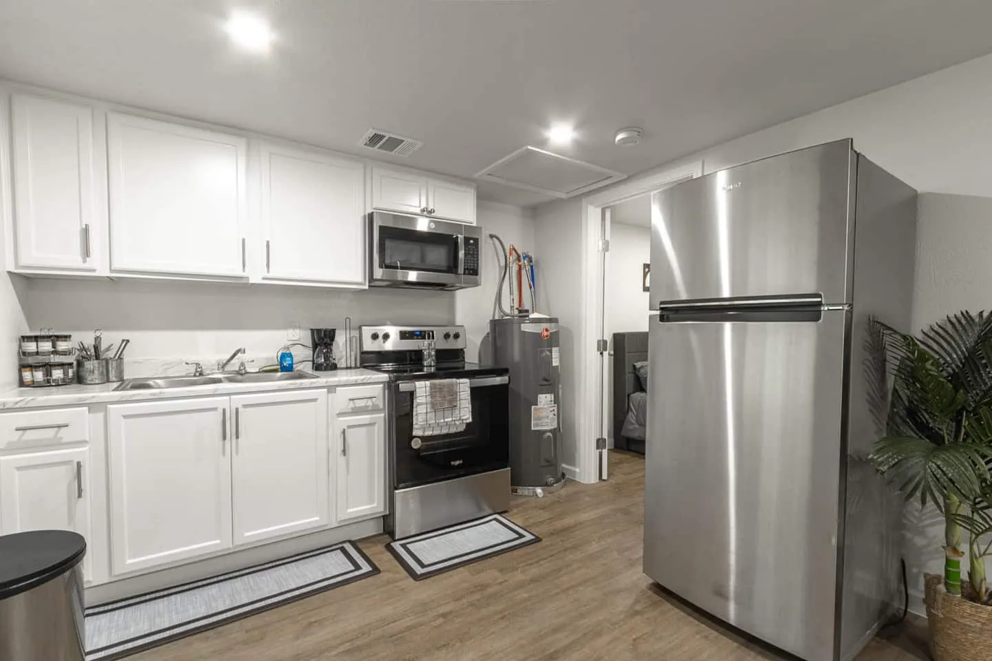 Unit 3 kitchen with white cabinets, a stove, microwave and stainless steel refrigerator